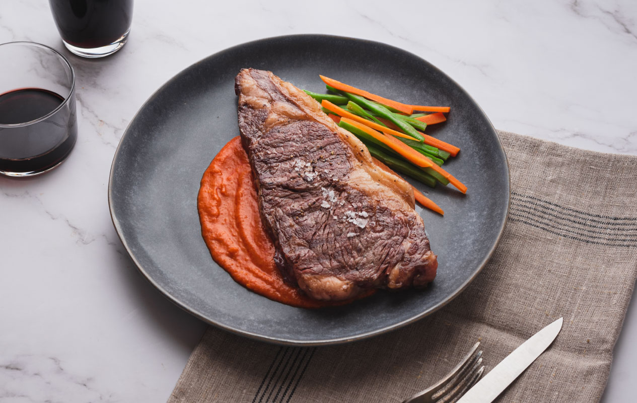 Chuletón con salsa de pimiento asado y naranja