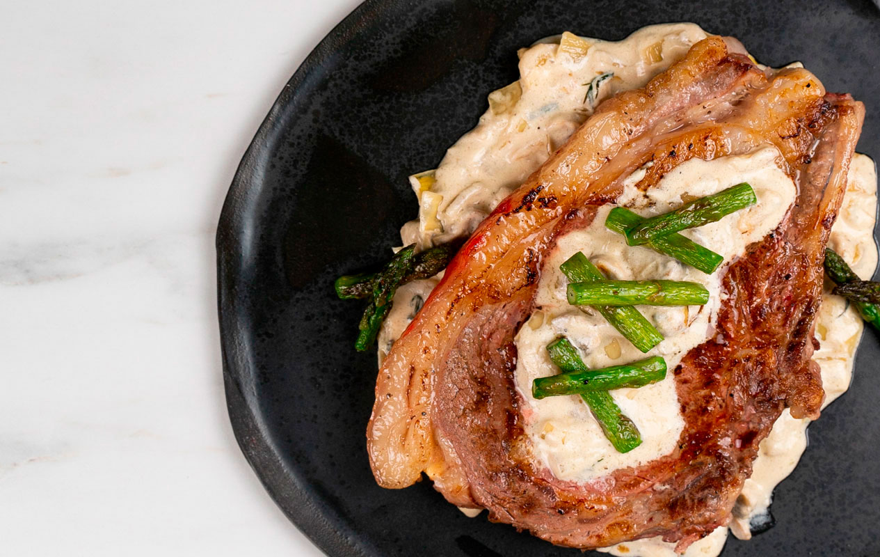 Chuletón de ternera con queso azul, setas y espárragos